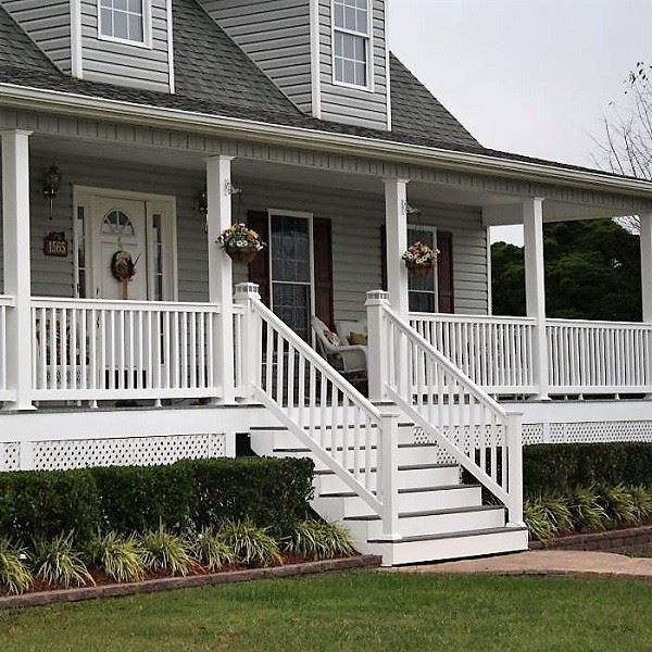White vinyl deck railing post base detail showing post sleeve over pressure-treated wood post with stainless steel standoff bracket installed above deck surface allowing water drainage and preventing end-grain moisture absorption White vinyl deck railing post base detail showing post sleeve over pressure-treated wood post with stainless steel standoff bracket installed above deck surface allowing water drainage and preventing end-grain moisture absorption
